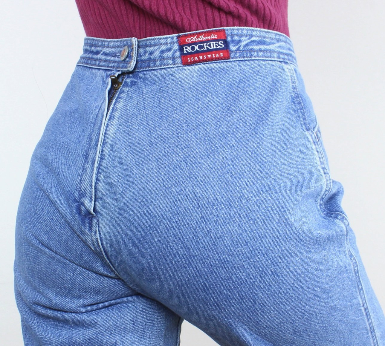 Back close-up of Authentic Rockies Jeanswear high-rise slim jeans with branded label in light blue stonewash denim